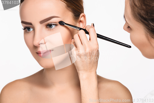Image of Beautiful female eyes with make-up and brush