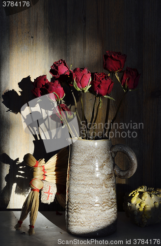 Image of autumn still life, dried rose, straw horse, pumpkin