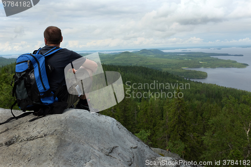 Image of tourist sits on a cliff in the national park Koli, Finland