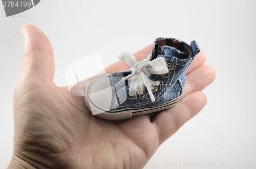 Image of tiny denim shoe on the palm