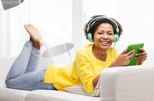 Image of happy african woman with tablet pc and headphones