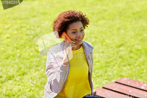Image of smiling african young woman calling on smartphone