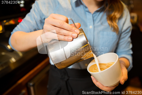 Image of close up of woman making coffee at shop or cafe