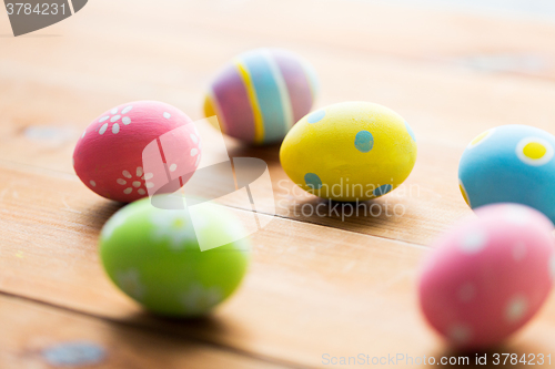 Image of close up of colored easter eggs on wooden surface