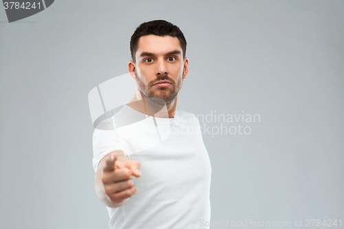 Image of angry man pointing finger to you over gray