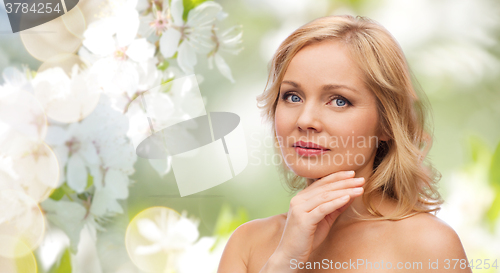 Image of woman with bare shoulders touching face