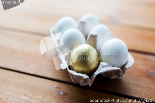 Image of close up of white and gold eggs in egg box