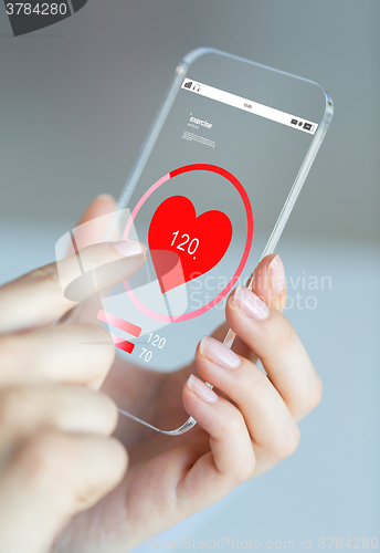 Image of close up of hand with heart rate on smartphone