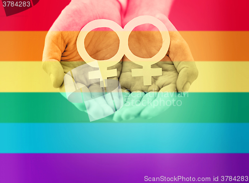 Image of close up of lesbian couple hands with venus symbol