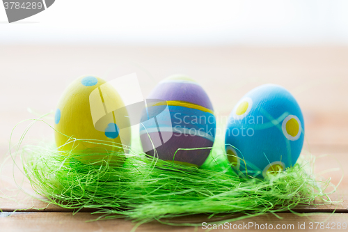 Image of close up of colored easter eggs and grass