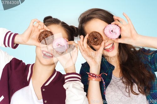 Image of happy pretty teenage girls with donuts having fun