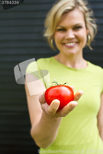 Image of Cute blond girl presenting vegetables