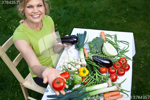 Image of Cute blond girl with vegetables