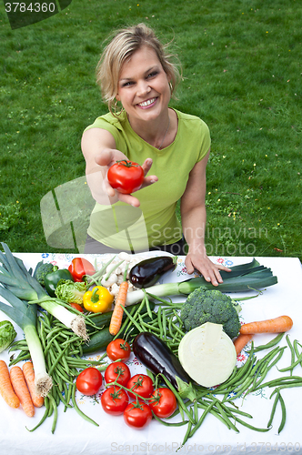 Image of Cute blond girl with vegetables