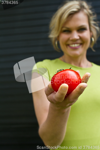 Image of Cute blond girl presenting vegetables