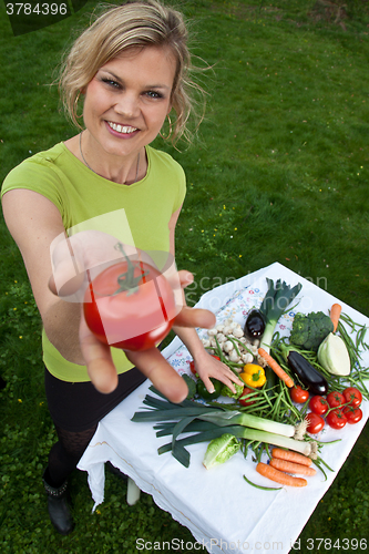 Image of Cute blond girl with vegetables