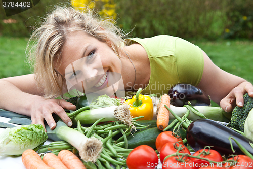 Image of Cute blond girl with vegetables