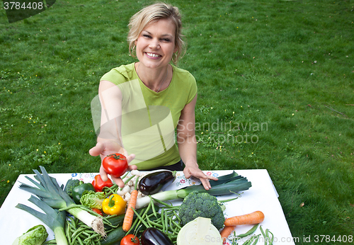 Image of Cute blond girl with vegetables