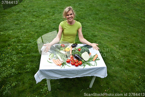 Image of Cute blond girl with vegetables