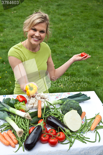 Image of Cute blond girl with vegetables