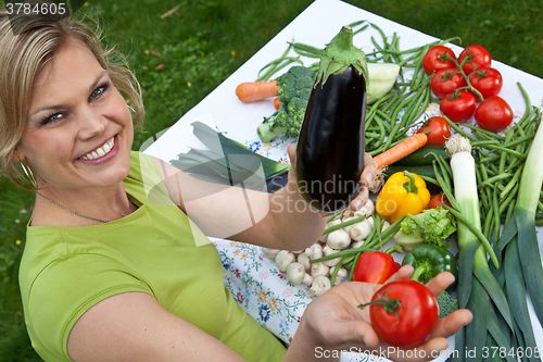 Image of Cute blond girl with vegetables