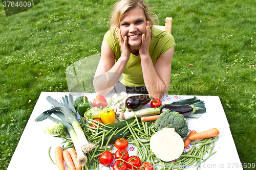 Image of Cute blond girl with vegetables