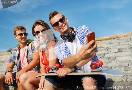 Image of happy friends with smartphone taking selfie