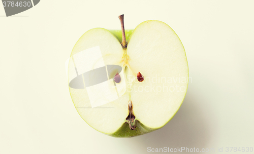 Image of ripe green apple half over white