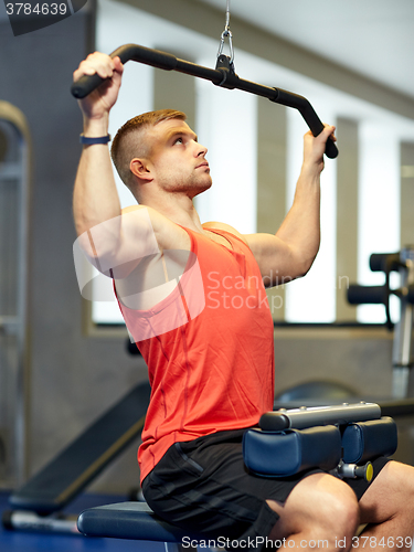 Image of man flexing muscles on cable machine gym