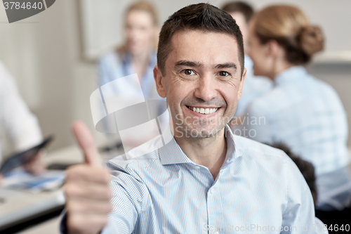 Image of group of smiling businesspeople meeting in office