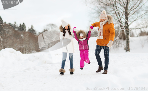 Image of happy family in winter clothes walking outdoors