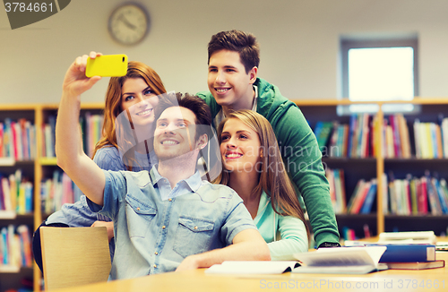 Image of students with smartphone taking selfie in library