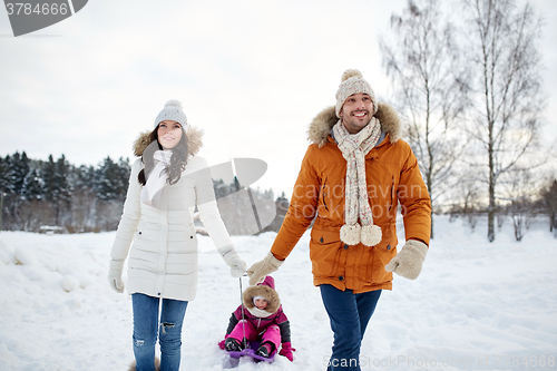 Image of happy family with sled walking in winter outdoors