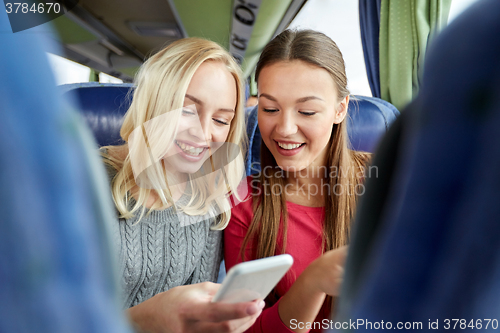 Image of happy young women in travel bus with smartphone