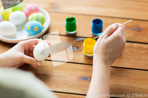 Image of close up of woman coloring easter eggs