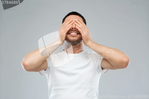 Image of smiling man closing his eyes over gray background