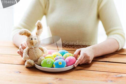 Image of close up of woman hands with easter eggs and bunny