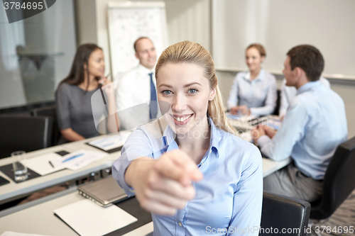Image of group of smiling businesspeople meeting in office