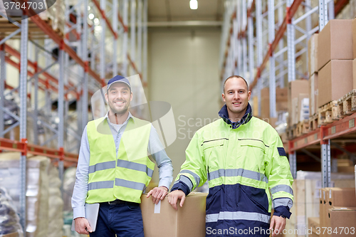 Image of men in uniform with boxes at warehouse