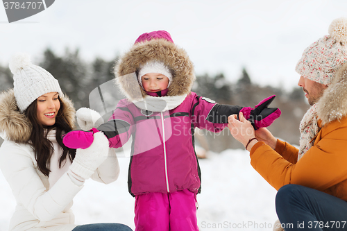 Image of happy family with child in winter clothes outdoors