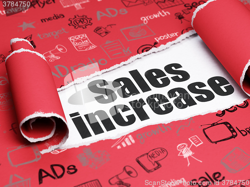 Image of Marketing concept: black text Sales Increase under the piece of  torn paper