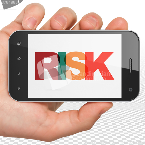 Image of Finance concept: Hand Holding Smartphone with Risk on  display