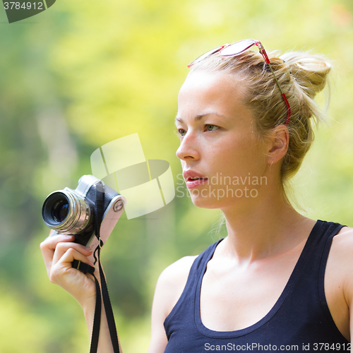 Image of Woman in nature with retro camera.