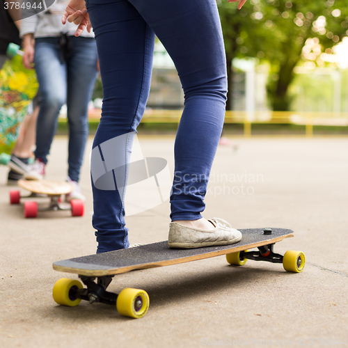 Image of Teenage girl practicing riding long board.