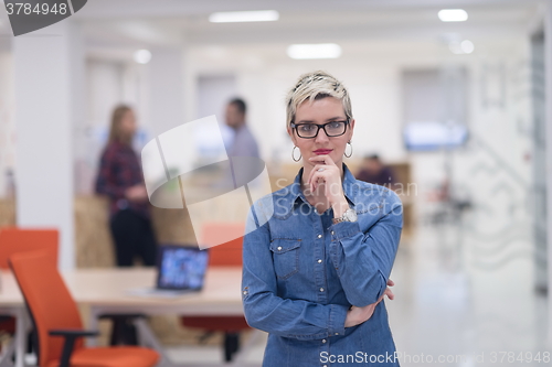 Image of portrait of young business woman at office with team in backgrou