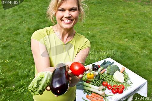 Image of Cute blond girl with vegetables