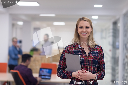 Image of portrait of young business woman at office with team in backgrou