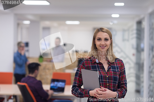 Image of portrait of young business woman at office with team in backgrou