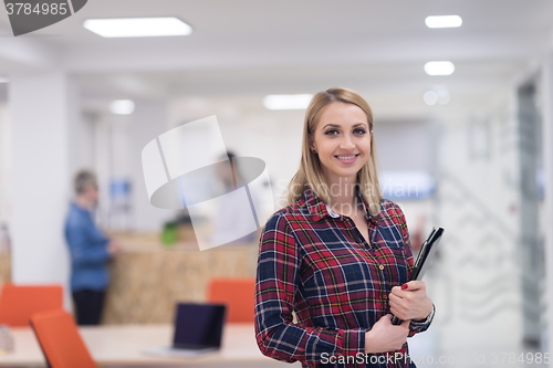 Image of portrait of young business woman at office with team in backgrou