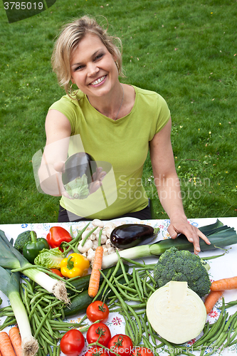 Image of Cute blond girl with vegetables
